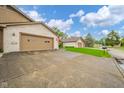 Long concrete driveway leads to an attached garage, set against a brick home with green lawns at 3537 Woodglen Way, Anderson, IN 46011