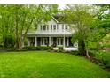 Beautiful two-story home featuring a spacious porch and a lush, green lawn at 4130 N Meridian St, Indianapolis, IN 46208