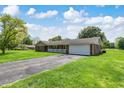 Brick ranch home featuring an attached two-car garage, a large yard, and a paved driveway at 4197 E 250 S, Franklin, IN 46131