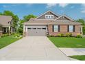 Charming home exterior featuring a gray garage door, brick accents, and a meticulously maintained front lawn at 5020 Eldon Dr, Noblesville, IN 46062