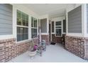 Cozy front porch featuring large windows, brick pillars, and a welcome sign for a warm, inviting entrance at 5020 Eldon Dr, Noblesville, IN 46062