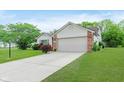 Inviting single-story home featuring a two-car garage, brick accents, and a neatly kept yard at 5083 Emmert Dr, Indianapolis, IN 46221