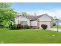 Well-maintained single-story home with a lush green lawn and attached garage at 5083 Emmert Dr, Indianapolis, IN 46221