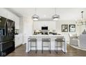 Modern eat-in kitchen features stainless steel appliances, white cabinets, and a breakfast bar at 542 Alder Way, Sheridan, IN 46069