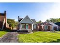 Charming brick home with a cozy front porch, swing, and a well-manicured lawn at 5428 E 10Th St, Indianapolis, IN 46219