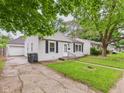 Street view of a traditional home featuring a detached garage and a neatly kept lawn at 602 W 34Th St, Anderson, IN 46013