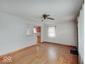 Cozy living room with hardwood floors leading to the kitchen area with a window at 6069 E 15Th St, Indianapolis, IN 46219