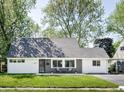 Charming Cape Cod-style home with a manicured lawn and a cozy front porch seating area at 6143 E 43Rd St, Indianapolis, IN 46226