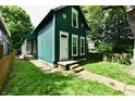 Quaint two-story home with charming curb appeal, featuring lush greenery and a welcoming entrance at 631 Prospect St, Indianapolis, IN 46203