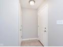 Neutral hallway featuring tiled floor, white doors, and light switch at 6410 Avacado Dr, Indianapolis, IN 46217