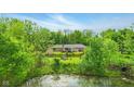 Spacious backyard with mature trees and pond, featuring a play set and a fenced-in area at 6462 Wings Ct, Brownsburg, IN 46112