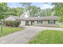 Charming ranch home featuring an attached garage and driveway at 7503 Grandview Dr, Indianapolis, IN 46260