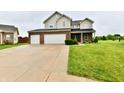 Inviting two-story home with a two-car garage, brick accents, and a lush green lawn at 7604 Cloudy Ct, Camby, IN 46113