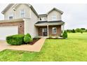 Charming home featuring a covered front porch, brick accents, and neatly landscaped garden beds at 7604 Cloudy Ct, Camby, IN 46113