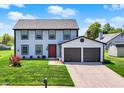 Charming two-story home with an attached two-car garage, a red front door and well-manicured lawn at 7670 Lippincott Way, Indianapolis, IN 46268