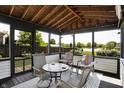 Relaxing screened-in porch featuring a rug, seating, and views of the outdoors and lake at 7670 Lippincott Way, Indianapolis, IN 46268