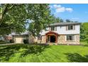 Two-story home with stone facade, attached garage, mature trees, and manicured lawn at 781 Dayton Dr, Carmel, IN 46033