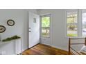 Bright entryway with hardwood floors, offering a glimpse of the outdoors through the glass paneled front door at 7835 E 50Th St, Indianapolis, IN 46226