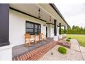 Inviting front porch with rocking chairs and a view of the property's expansive green lawn at 7895 E 175 N, Franklin, IN 46131