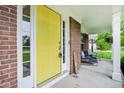 Inviting front porch featuring a vibrant yellow door and comfortable seating at 9311 Windrift Way, Zionsville, IN 46077