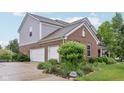 Attached three car garage with lush landscaping around the side and back at 9311 Windrift Way, Zionsville, IN 46077