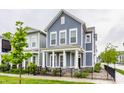 Inviting two-story home boasts a covered front porch and lush landscaping, enhancing its curb appeal in a friendly neighborhood at 965 Astor Ln, Carmel, IN 46032