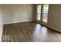 Bright living room featuring large windows and vinyl plank flooring, creating a warm, inviting space at 1002 Brookside Ln, Plainfield, IN 46168