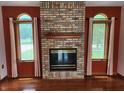 Bright living room with a brick fireplace and natural light from large windows at 1026 Summer Way Dr, Shelbyville, IN 46176