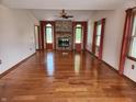 Open living room featuring hardwood floors and a brick fireplace at 1026 Summer Way Dr, Shelbyville, IN 46176
