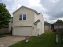A bright two-story home featuring a two-car garage and well-kept lawn at 10795 Albertson Dr, Indianapolis, IN 46231