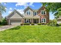 Charming two-story home featuring a well-manicured lawn, covered front porch, and an American flag at 10988 Eaton Ct, Fishers, IN 46038
