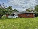 View of the back of the house showing the enclosed patio and large fenced-in backyard at 1103 Canal St, Anderson, IN 46012