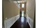 Bright foyer with dark hardwood floors, wainscoting, and a modern light fixture at 14462 Brook Meadow Dr, McCordsville, IN 46055