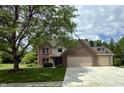 Traditional brick home boasts mature trees, attached two-car garage, and a well-maintained front lawn at 14814 Beacon Blvd, Carmel, IN 46032