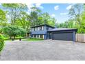 Home exterior featuring a lush green lawn and large tree in front of a well-maintained home at 1829 Kessler Blvd W Dr, Indianapolis, IN 46228