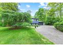 Home exterior features a lush green lawn and large tree in front of a well-maintained home at 1829 Kessler Blvd W Dr, Indianapolis, IN 46228