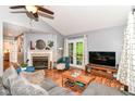 Bright living room featuring a fireplace, hardwood floors, neutral paint, and French doors to the outside at 3348 Fox Orchard Cir, Indianapolis, IN 46214
