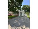 Charming single-story home with brick accents and green siding, complemented by a long concrete driveway at 3646 Creston Dr, Indianapolis, IN 46222