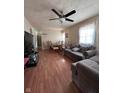 Cozy living room with hardwood floors, a ceiling fan, a comfortable sofa and a view into dining area at 3646 Creston Dr, Indianapolis, IN 46222