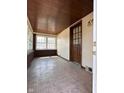 Enclosed front porch with tiled flooring, wood plank ceiling, and natural light from multiple windows at 3646 Creston Dr, Indianapolis, IN 46222