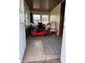Inviting sunroom with tiled floor featuring multiple windows, and a red toy car at 3646 Creston Dr, Indianapolis, IN 46222