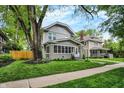 Charming home showcasing well-manicured lawn, mature trees, and a classic two-story design at 3918 N Park Ave, Indianapolis, IN 46205