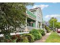 Charming light blue two-story home with green trim, white porch railing, and lush front yard landscaping at 455 S Pine St # 4, Indianapolis, IN 46203