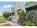 Side view of light blue home featuring a landscaped yard, covered porches, and classic architectural details at 455 S Pine St # 4, Indianapolis, IN 46203