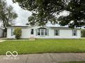 Charming single-story home with white siding, blue shutters, and manicured front lawn at 4617 Autumn Ridge Dr, Columbus, IN 47203