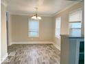 Light filled dining room with modern light fixture, large windows, and new floors at 4943 S State Ave, Indianapolis, IN 46227