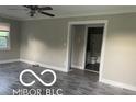 Inviting living room featuring modern gray flooring and neutral paint, with a view to the bathroom at 4943 S State Ave, Indianapolis, IN 46227