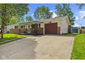 Ranch-style home featuring a spacious driveway, brick accents, and an attached single-car garage at 5115 Bertha St, Indianapolis, IN 46241