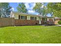 A well-maintained home featuring brick accents, a covered front porch, and a green lawn at 5115 Bertha St, Indianapolis, IN 46241