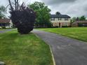 Charming two-story home with a well-manicured lawn and long driveway at 5433 Brendonridge Rd, Indianapolis, IN 46226